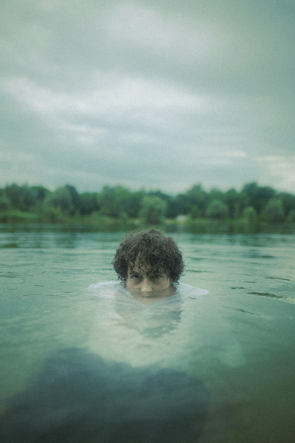 boy in water under cloudy sky during daytime