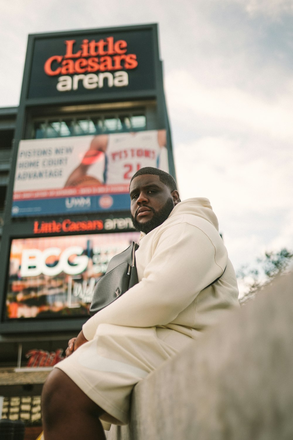 man in white coat standing near store during daytime