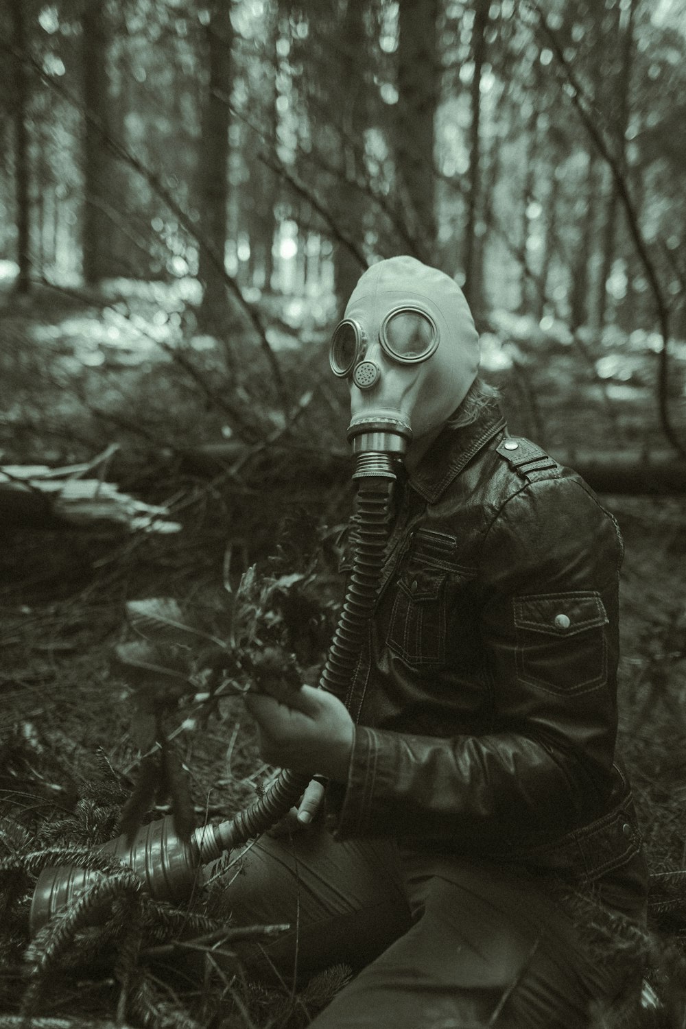 grayscale photo of person wearing gas mask and jacket