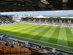 Workers shaping and preparing a sports ground with heavy machinery