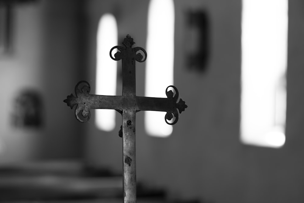 grayscale photo of cross with candles