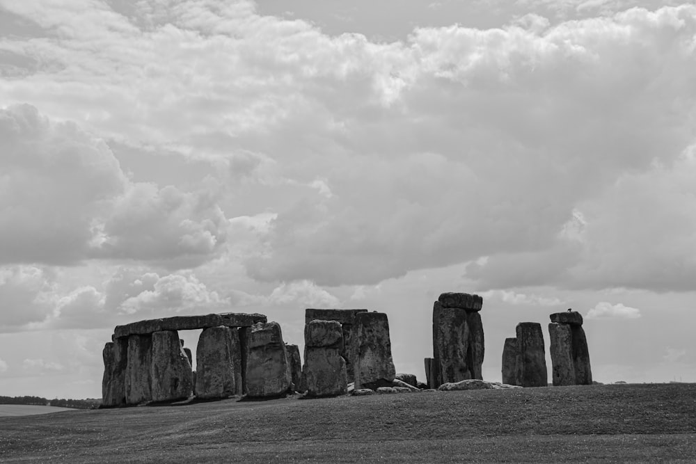 grayscale photo of rock formation under cloudy sky