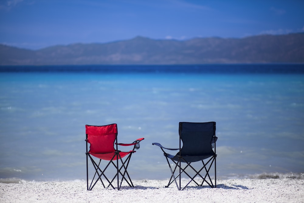 red and black folding chair on white sand during daytime