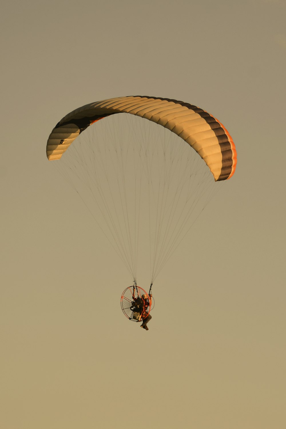 2 person riding on red and yellow parachute