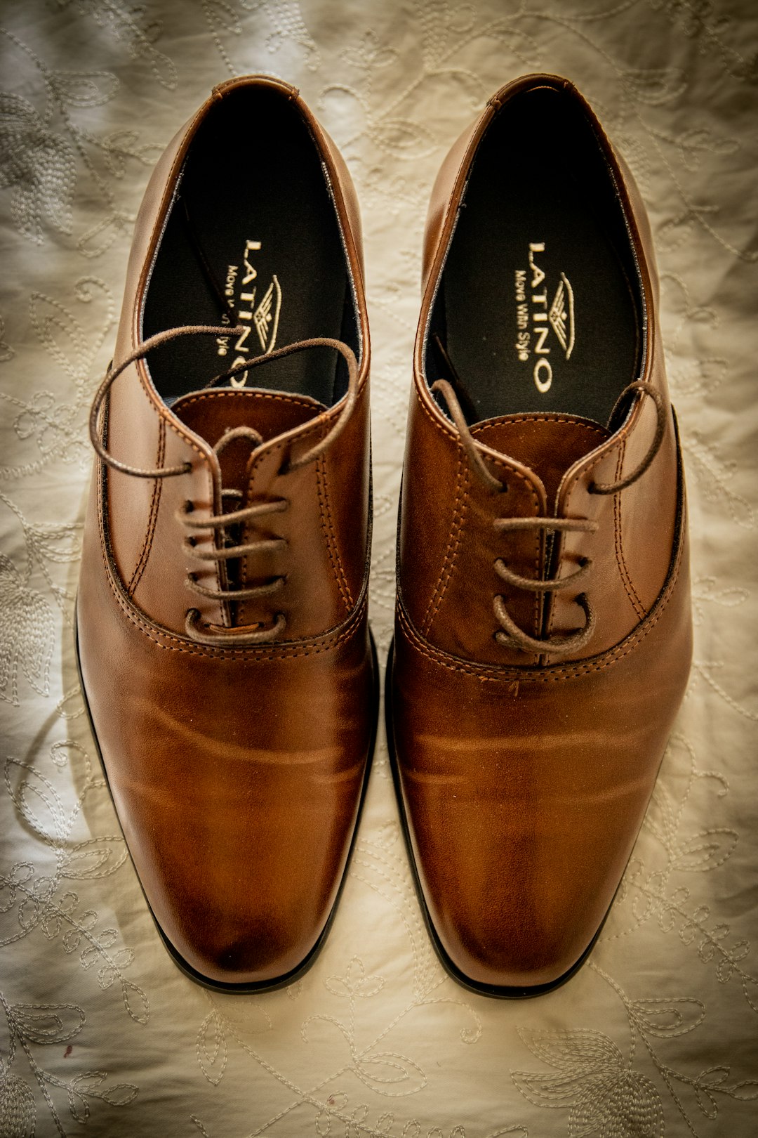 brown leather shoes on white textile