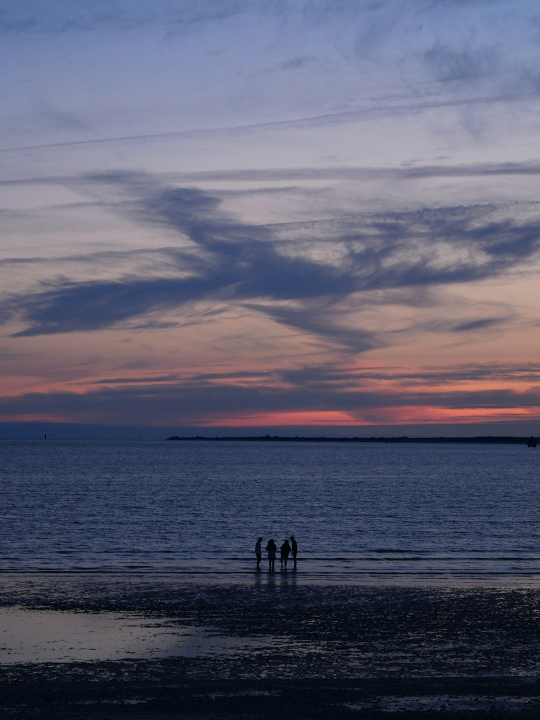 silhouette of 2 person standing on beach during sunset