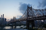 gray bridge over body of water under cloudy sky during daytime