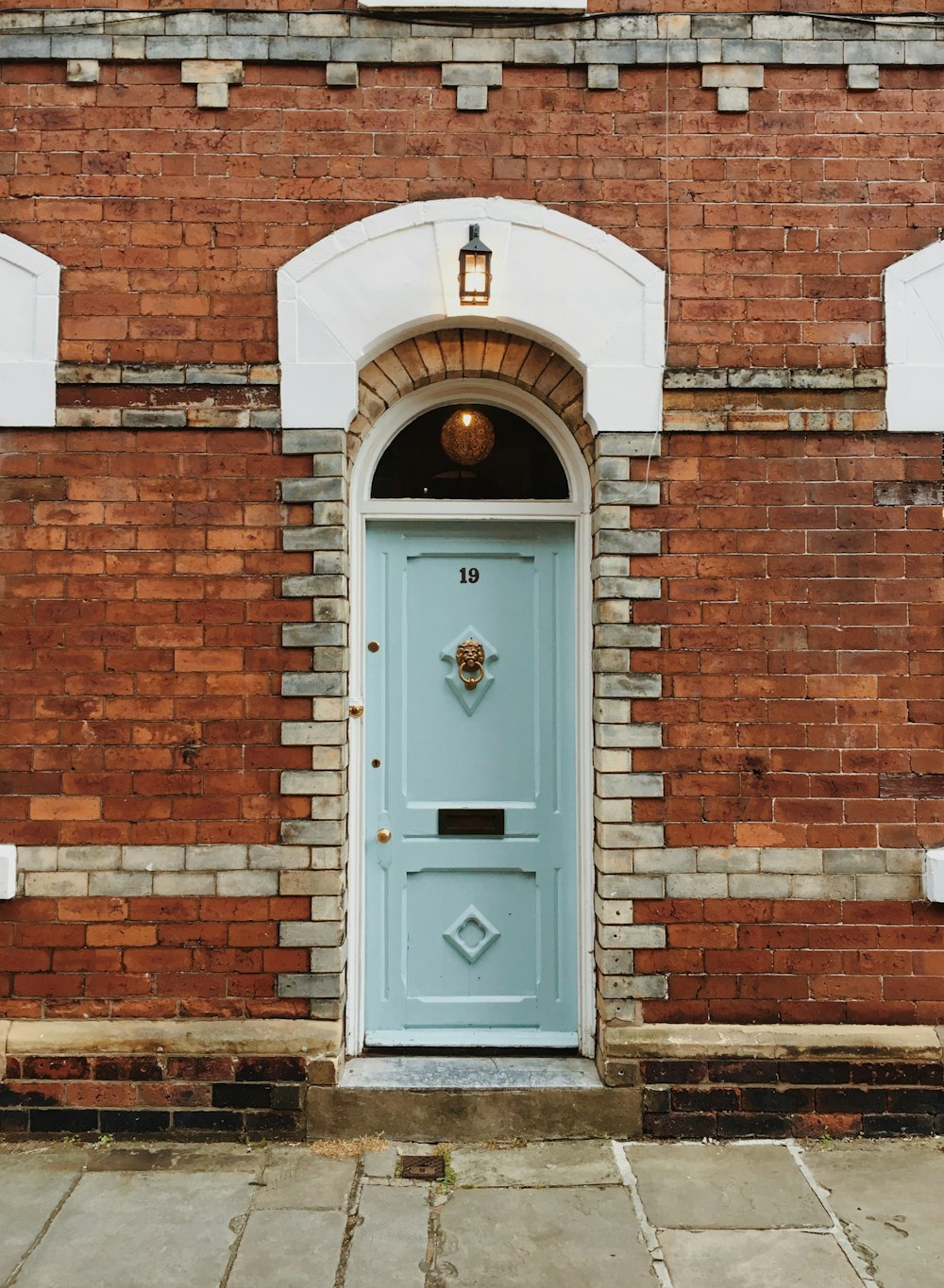 white wooden door on brown brick wall