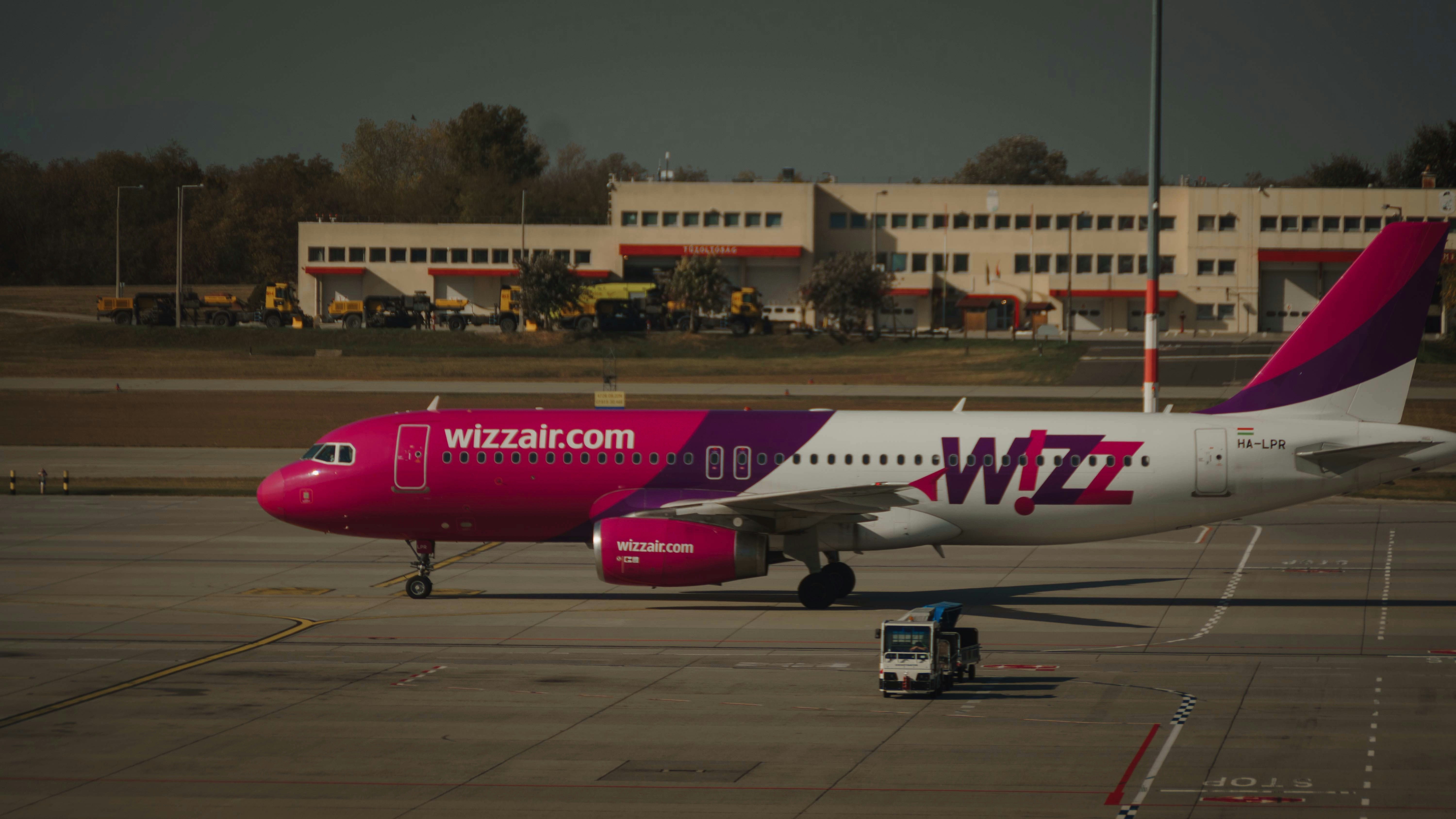 red and white passenger plane on airport during daytime