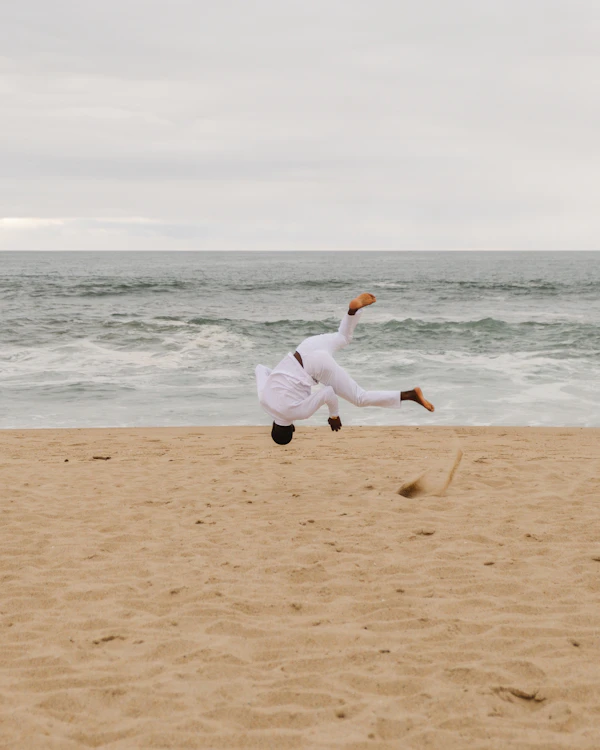 A woman in white running along the beach