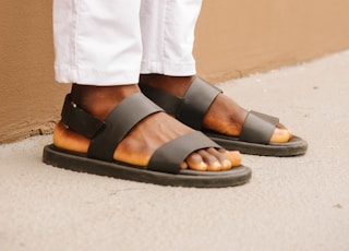 person wearing black leather sandals
