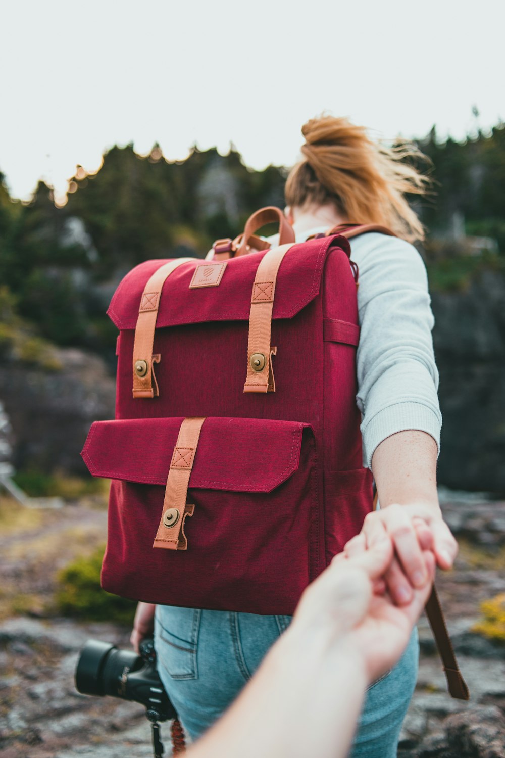 woman in white long sleeve shirt carrying brown and black backpack