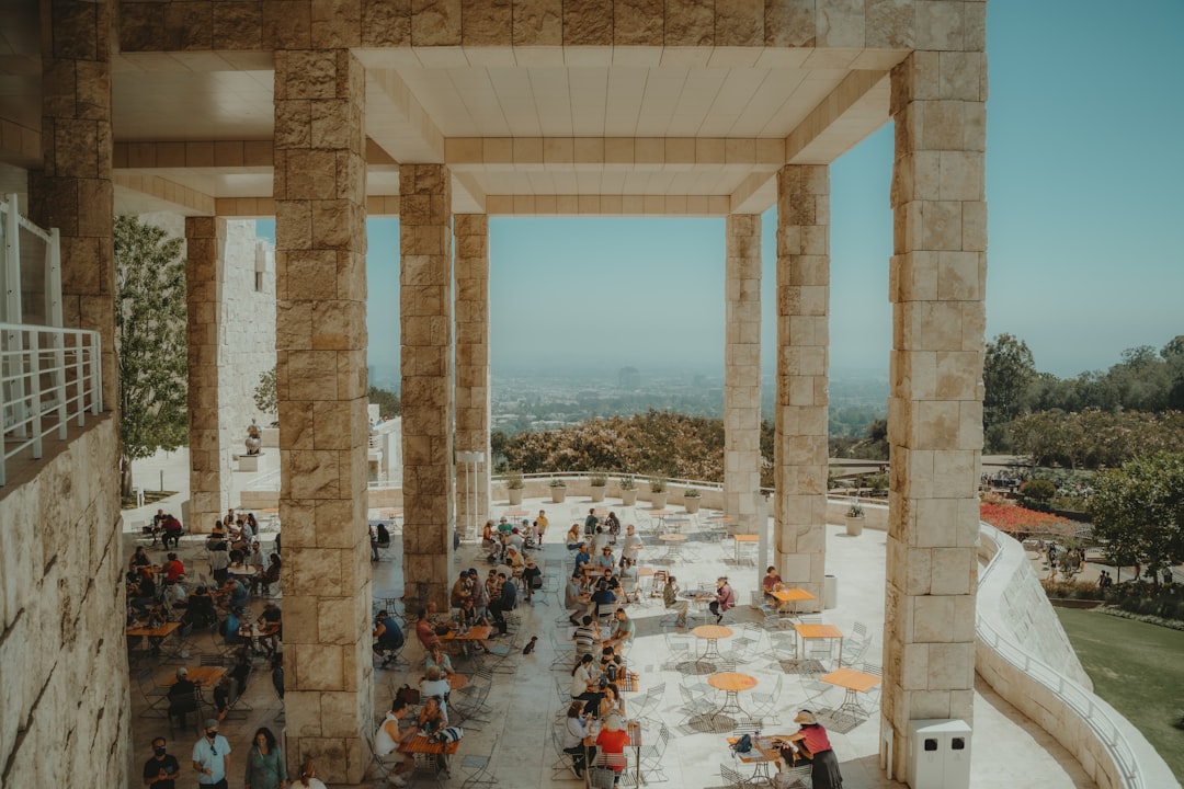 people sitting on chairs near table and body of water during daytime