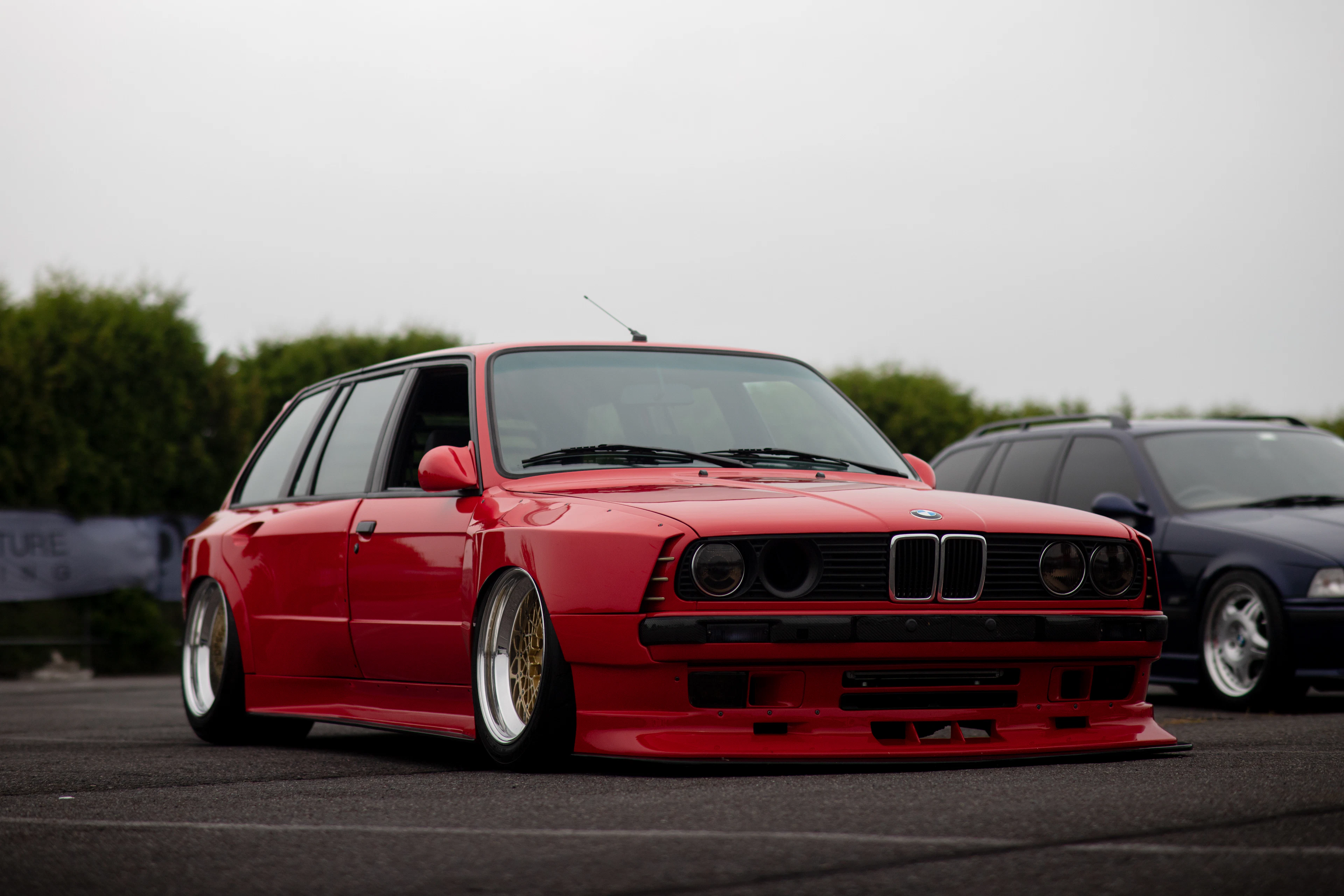 Lowered red BMW E30 on deep-dish wheels