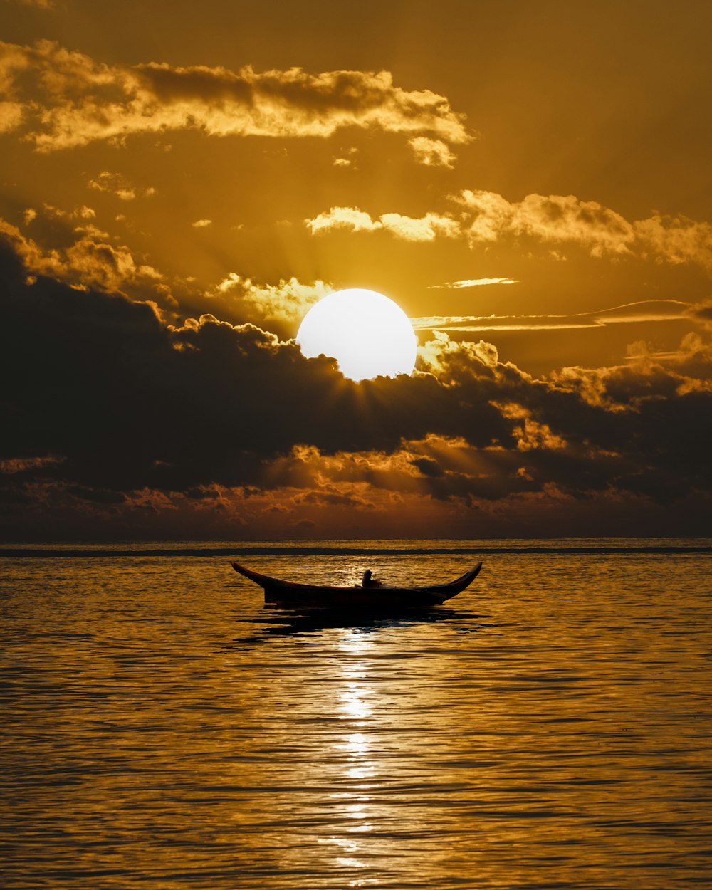 silhouette of boat on sea during sunset