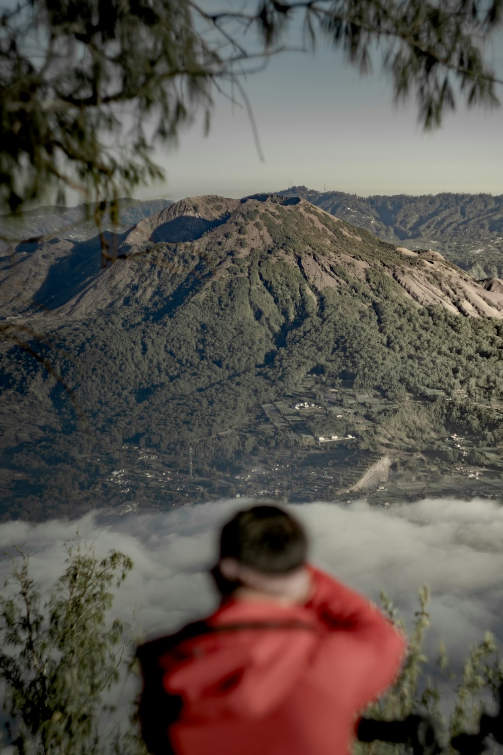 person in red hoodie standing near snow covered mountain during daytime