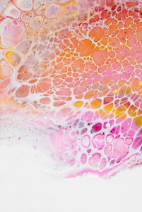 The image consists of an abstract pattern featuring interconnected, organic shapes with a lace-like texture. Bright colors such as pink, orange, and white are distributed across the image, creating a vivid and dynamic appearance. The shapes seem to overlap and blend seamlessly, giving a fluid and artistic effect.