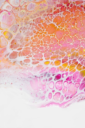 The image consists of an abstract pattern featuring interconnected, organic shapes with a lace-like texture. Bright colors such as pink, orange, and white are distributed across the image, creating a vivid and dynamic appearance. The shapes seem to overlap and blend seamlessly, giving a fluid and artistic effect.