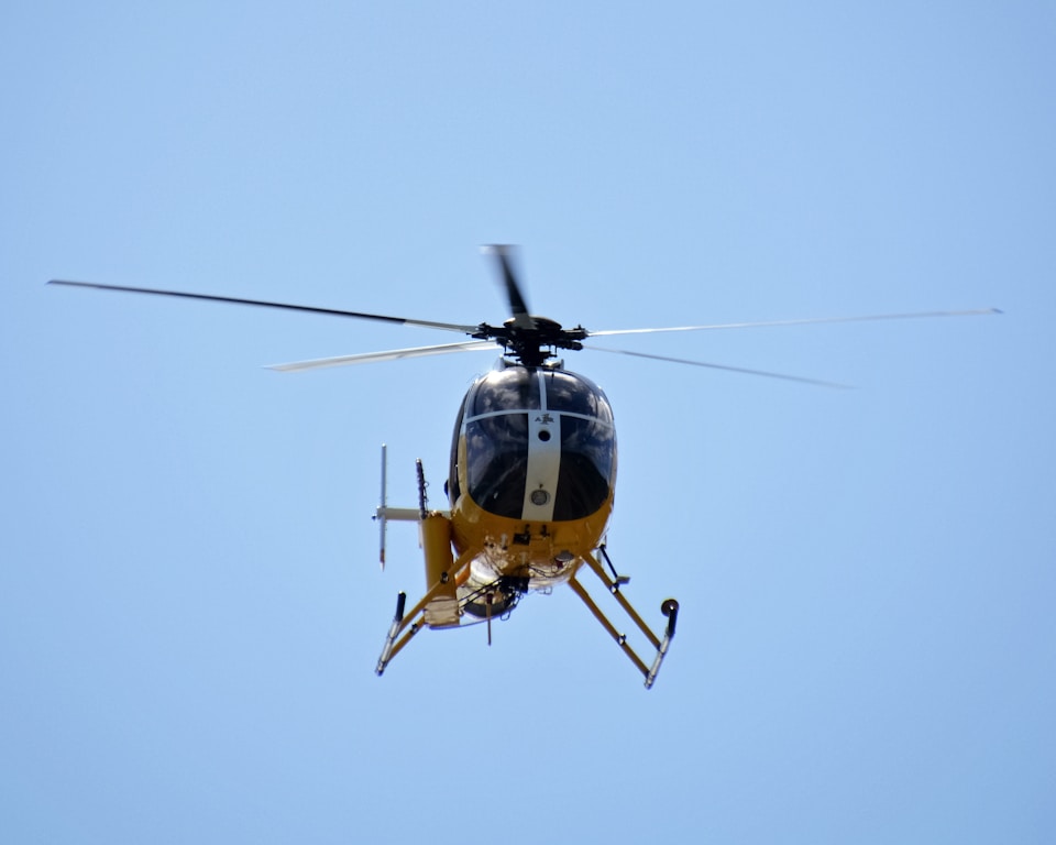 yellow and black helicopter flying in the sky