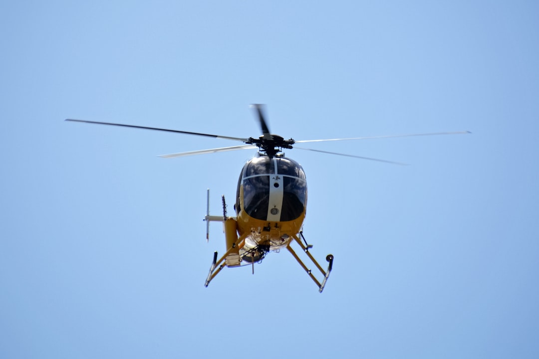 yellow and black helicopter flying in the sky