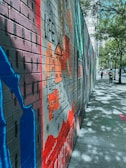 A colorful mural depicting a cityscape on a brick wall.
