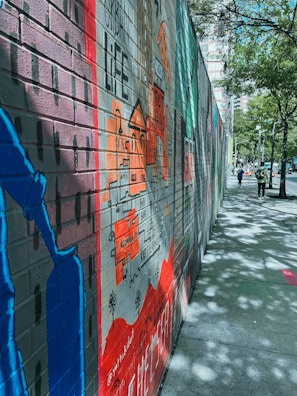 A colorful mural depicting a cityscape on a brick wall.