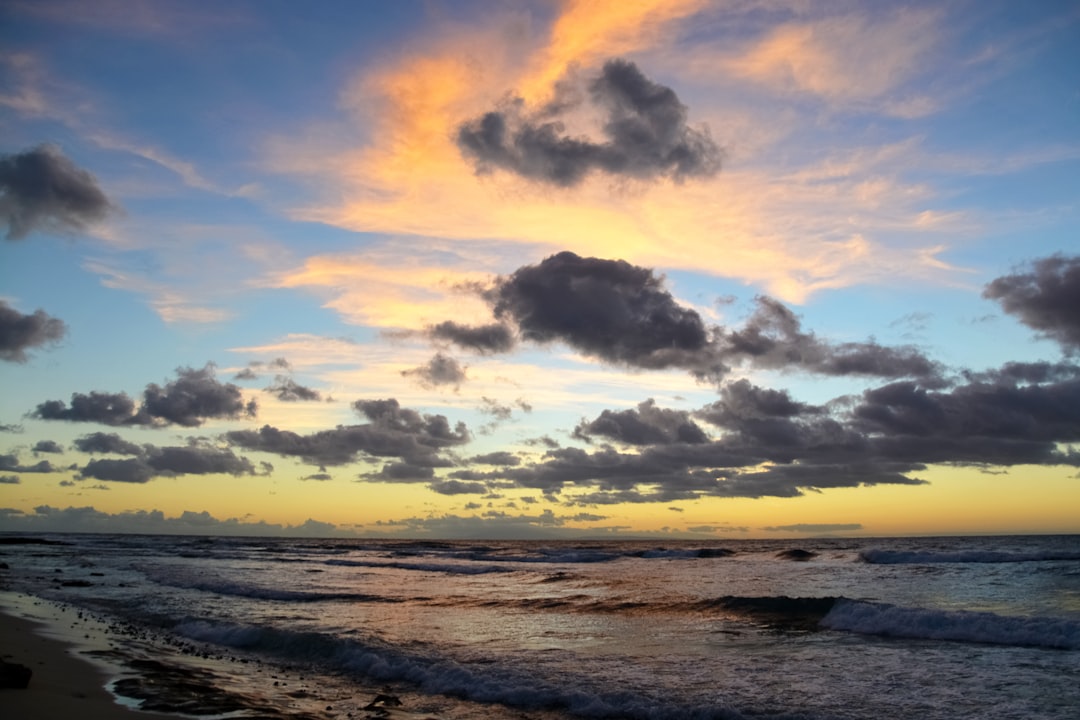 sea waves crashing on shore during sunset