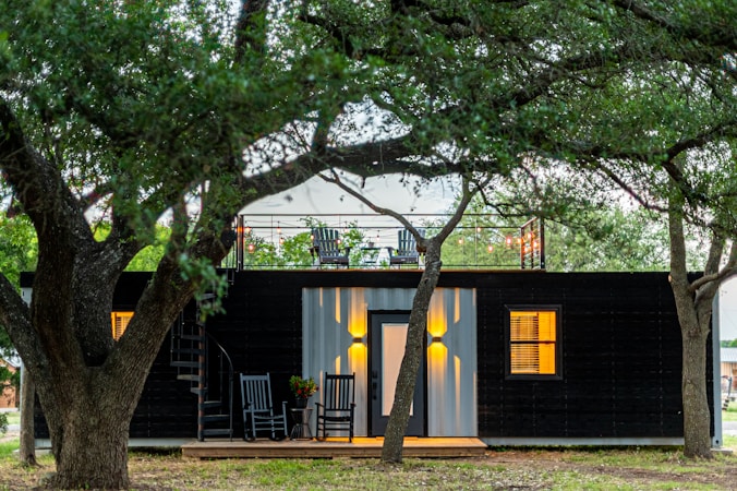 A compact wooden tiny home with modern design near green landscaping
