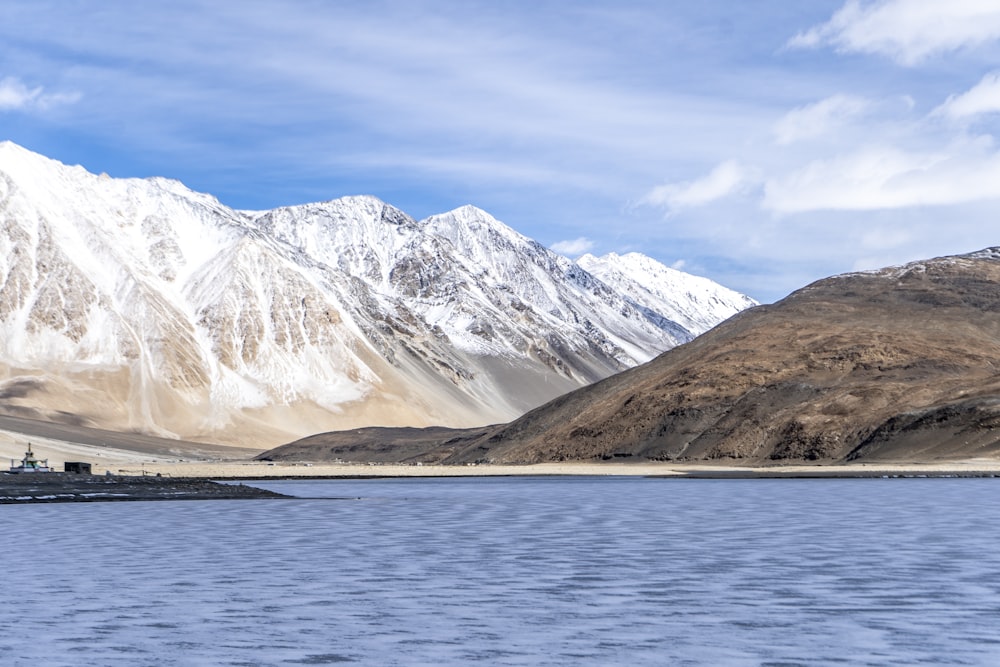 Montañas cubiertas de nieve cerca del cuerpo de agua durante el día