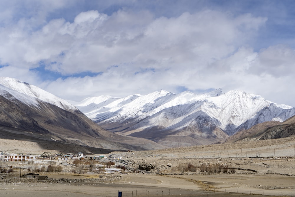 white and brown mountains under white clouds and blue sky during daytime