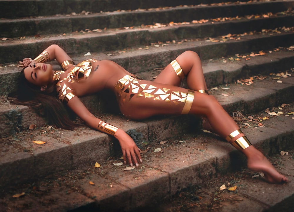 woman in brown leather lingerie lying on concrete stairs