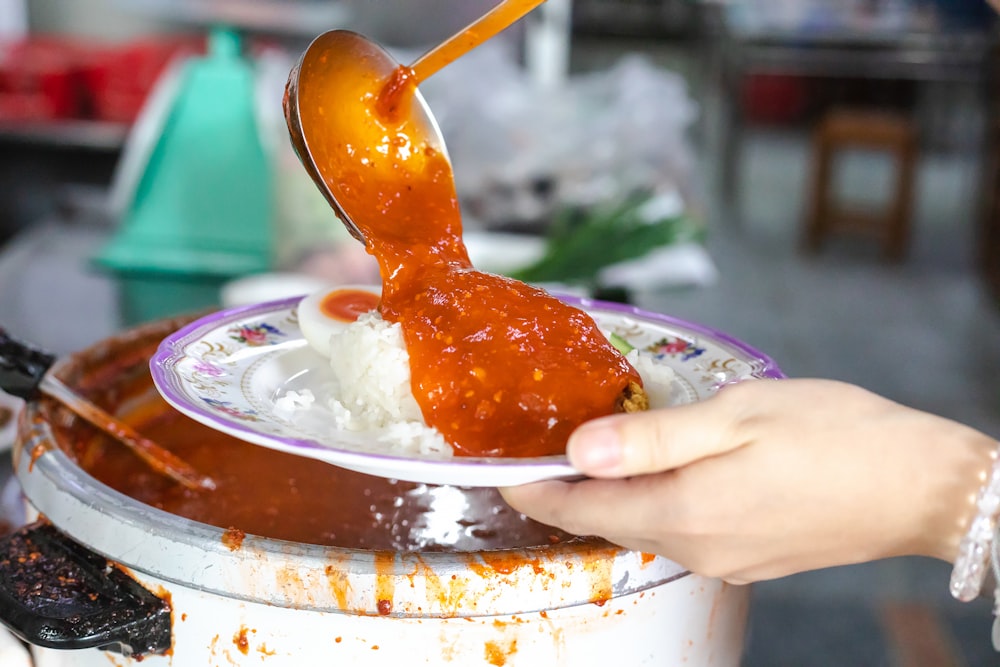 person holding stainless steel spoon