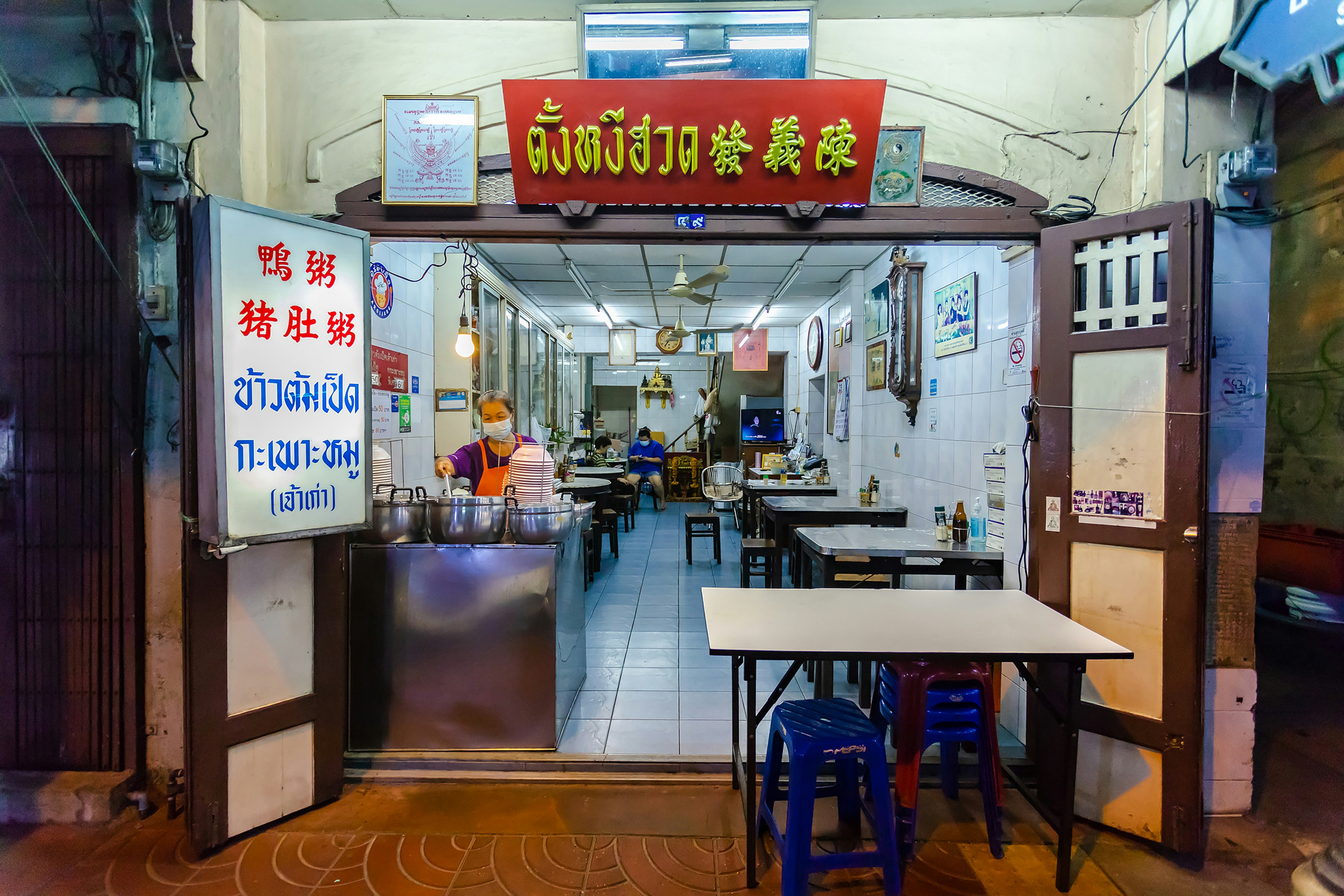 brown wooden table near white wall, The old shophouse Tang Ngee Huad in Bangkok. Come here for jok (congee) rice porridge with duck.</p><p>
