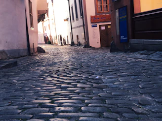 Empty cobblestone street framed by softly lit classical buildings, capturing a peaceful early hour.
