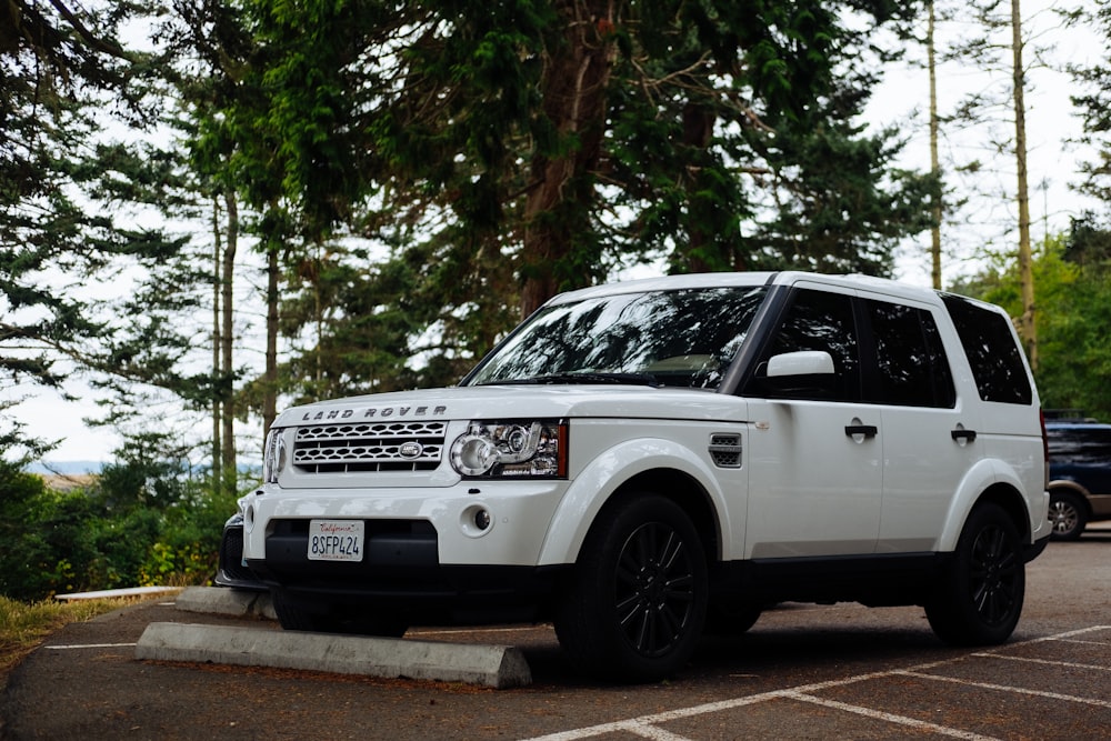 white land rover range rover suv parked on road during daytime