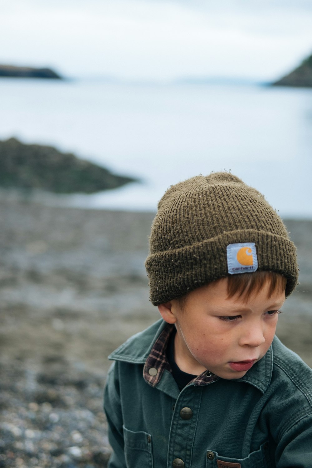 boy in brown knit cap and gray jacket