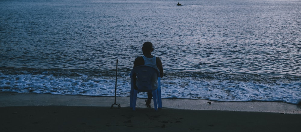 man in blue shirt standing on beach during daytime