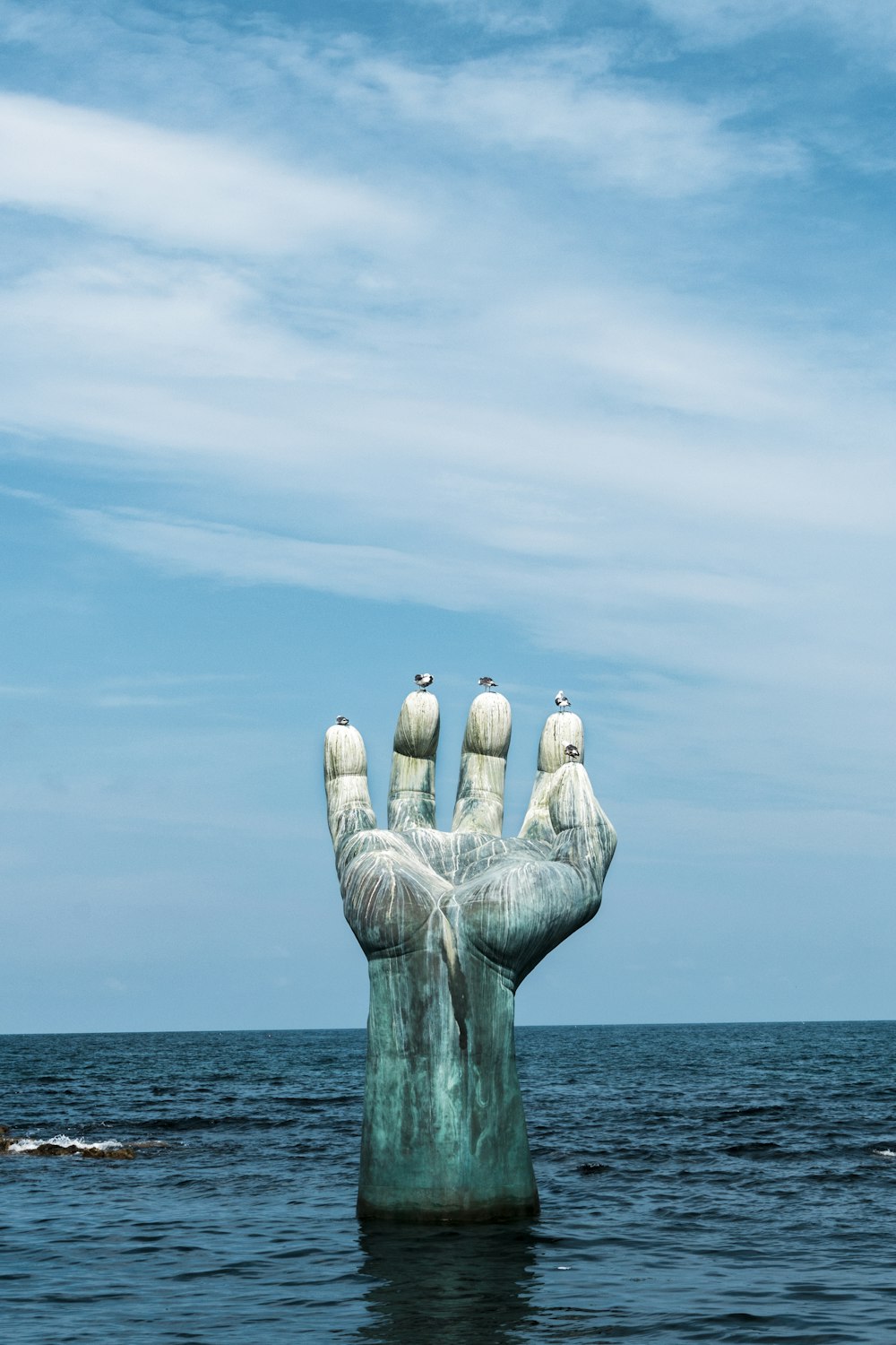 3 white bird on gray concrete statue under blue sky during daytime