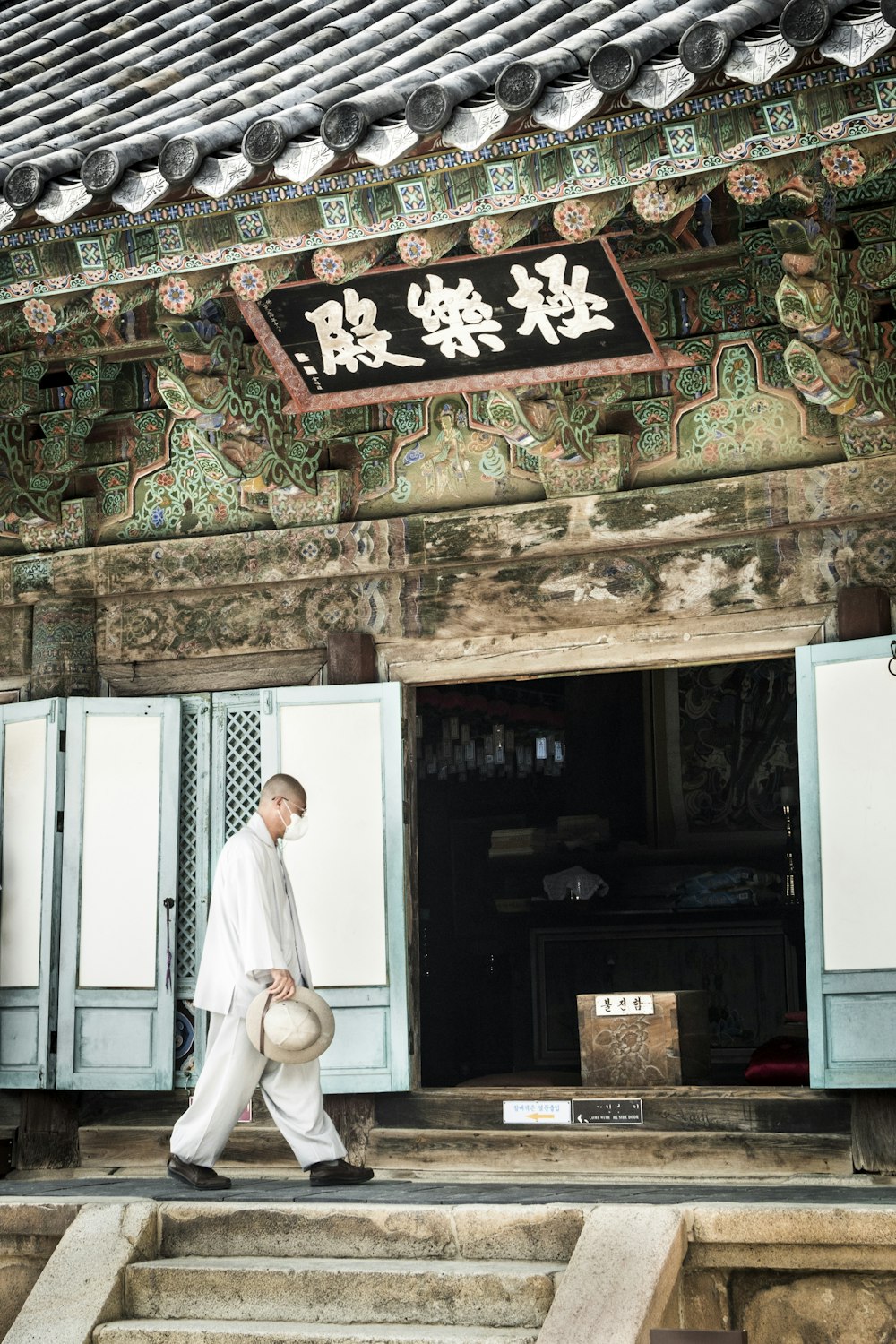 man in white thobe standing near white wooden door