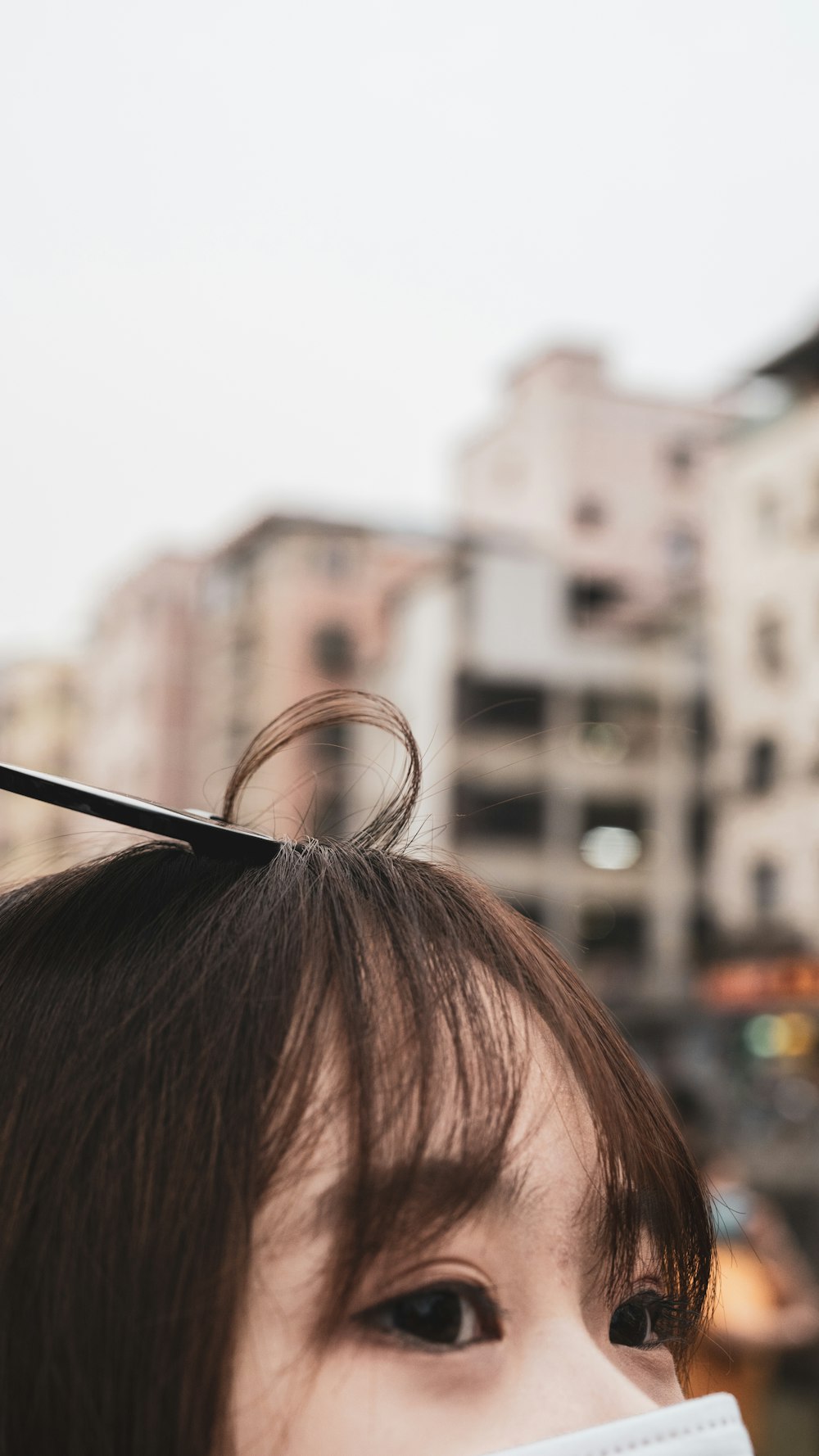 womans brown hair in front of white concrete building during daytime