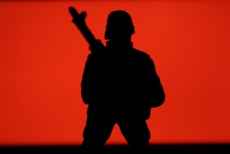 A stoic soldier silhouette against a matte black background, embodying resilience and discipline.