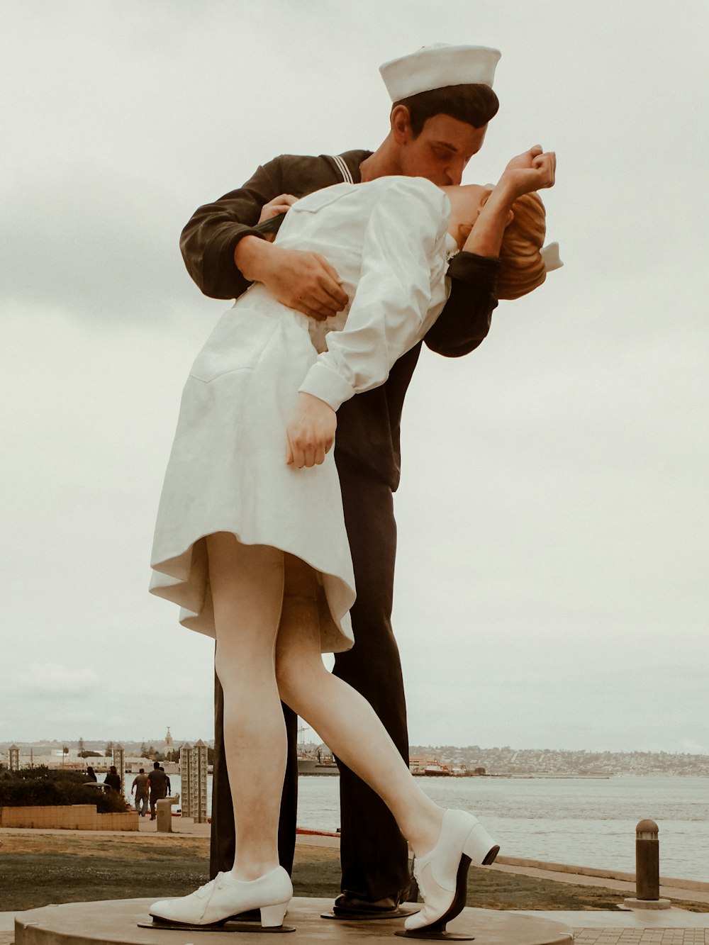 man in white dress shirt and brown dress pants carrying woman in white dress