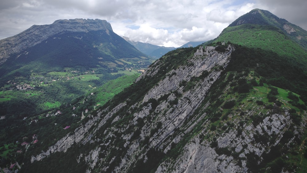 montagne verte et noire sous des nuages blancs pendant la journée