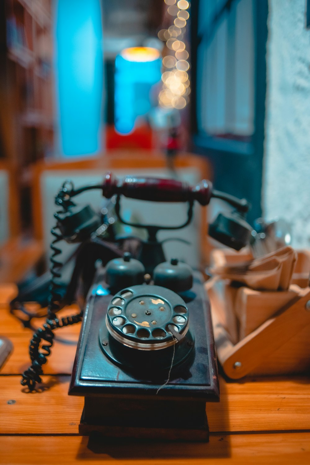 茶色の木製のテーブルに黒い回転式電話
