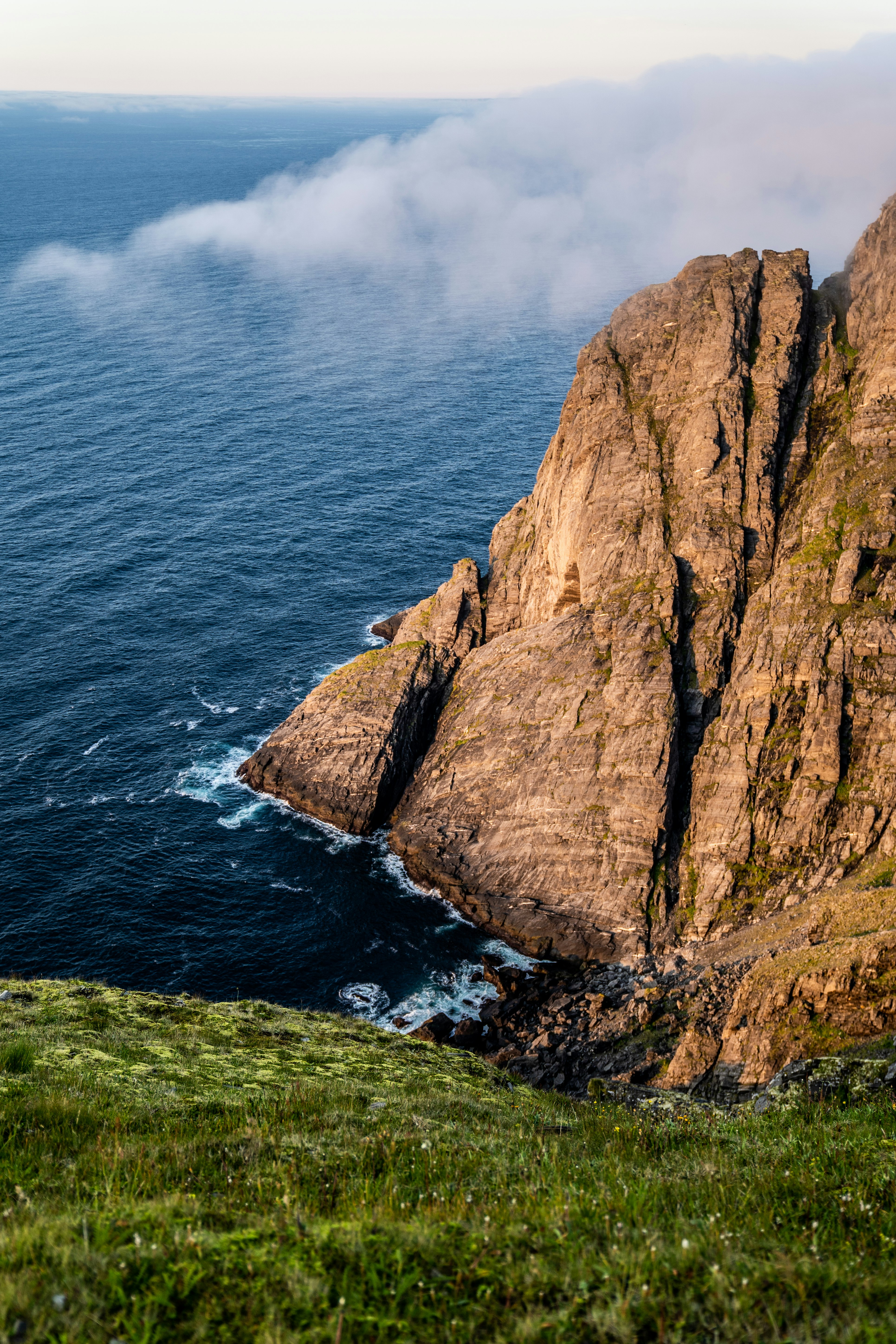 brown rock formation beside body of water during daytime