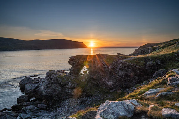 Midnight sun low over the rocky shoreline at Skarsvåg in northern Norway