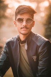 Person wearing elegant sunglasses outdoors, sunlight highlighting the frame design.