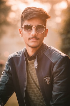 Person wearing elegant sunglasses outdoors, sunlight highlighting the frame design.