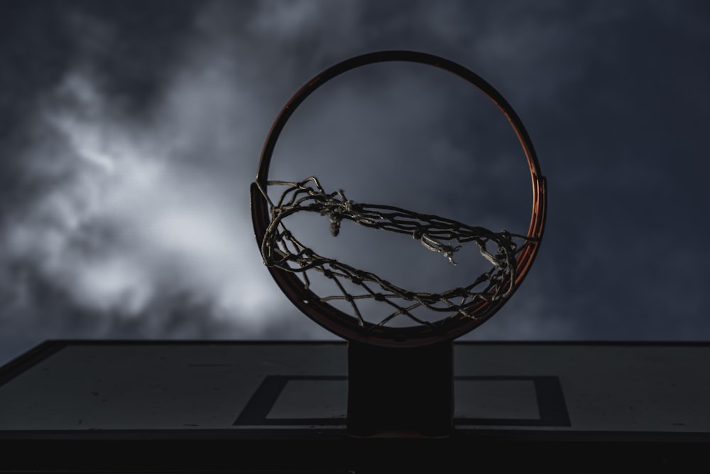 brown and black basketball hoop under cloudy sky