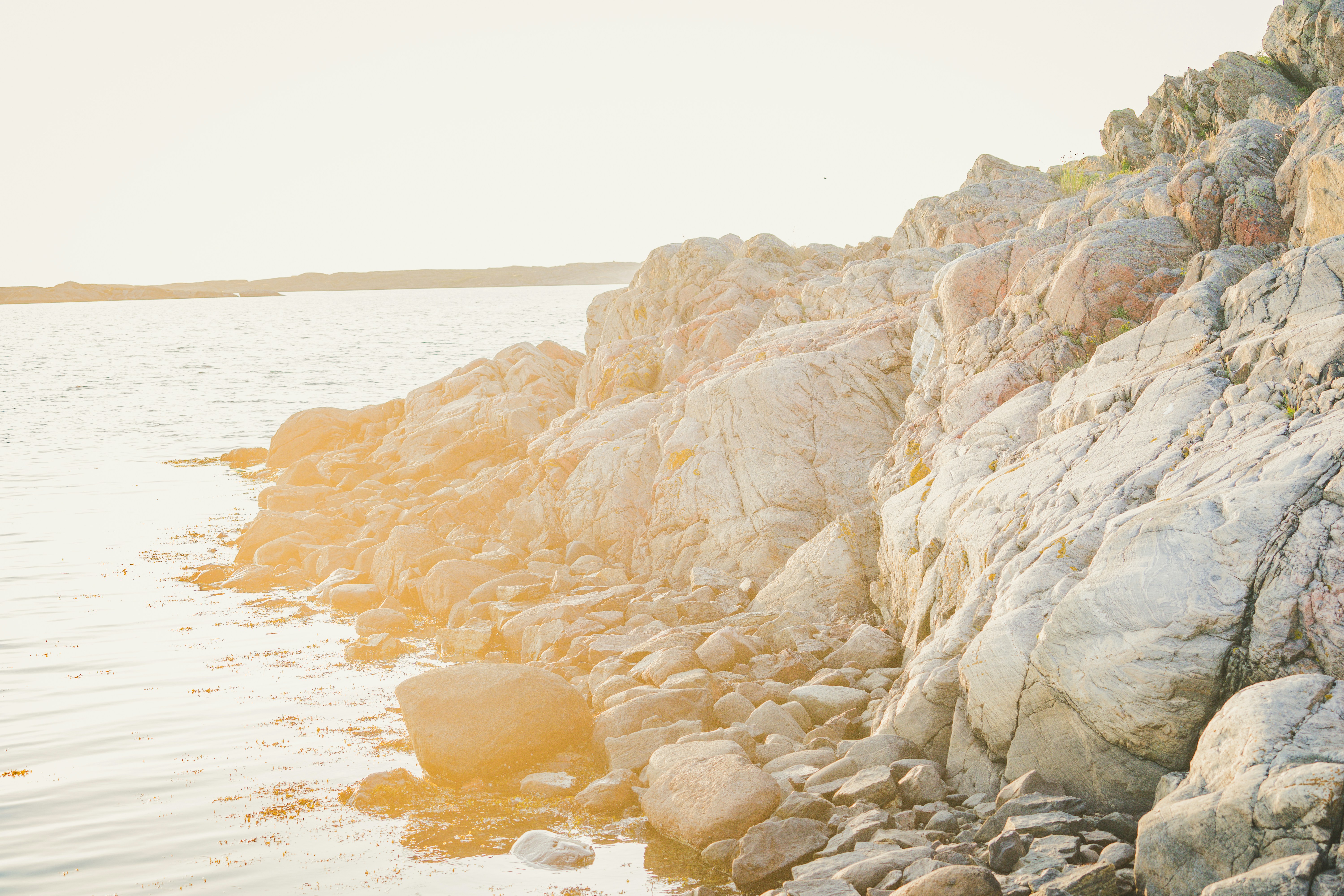 brown rocky mountain by the sea during daytime